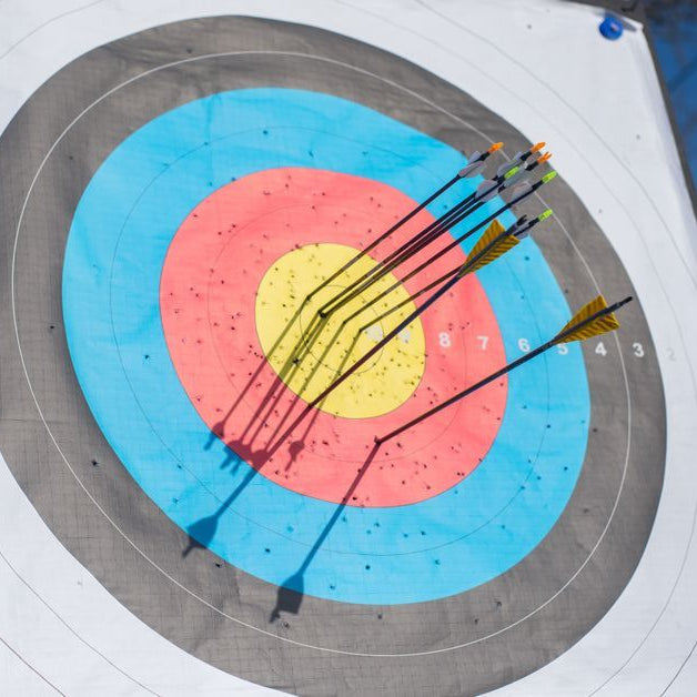 Several arrows hitting a colorful archery target