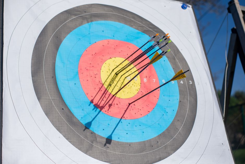 Several arrows hitting a colorful archery target